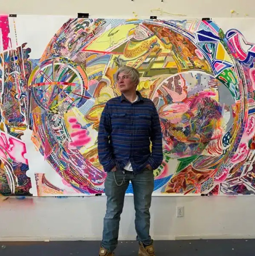 Abstract painter Emanuela Sintamarian standing in front of a complex, patterned contemporary painting.