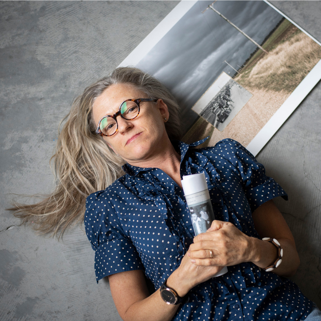 Photographer and installation artist Renee Billingslea posing with a historic conceptual photo display.