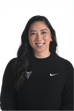 Professional headshot of smiling woman in black sweater Woman with long dark hair smiling at the camera against a light background, wearing a black sweater.