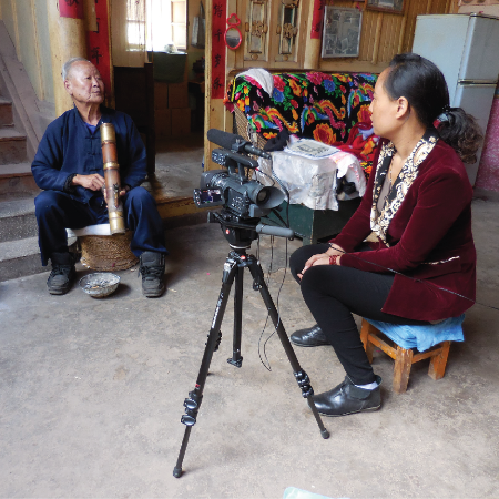 Woman interviewing older man on camera