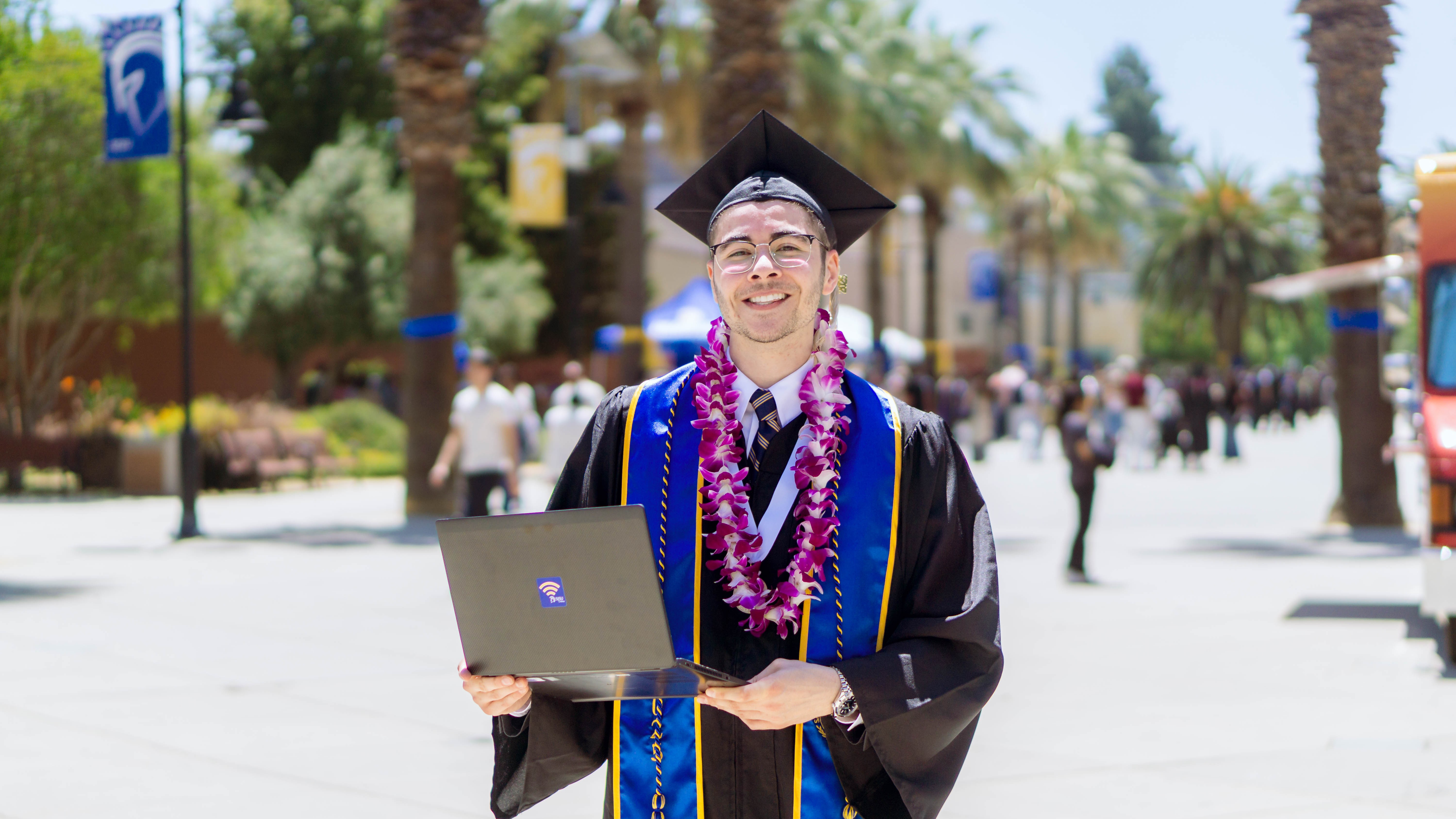 SJSU Online graduate smiling with laptop