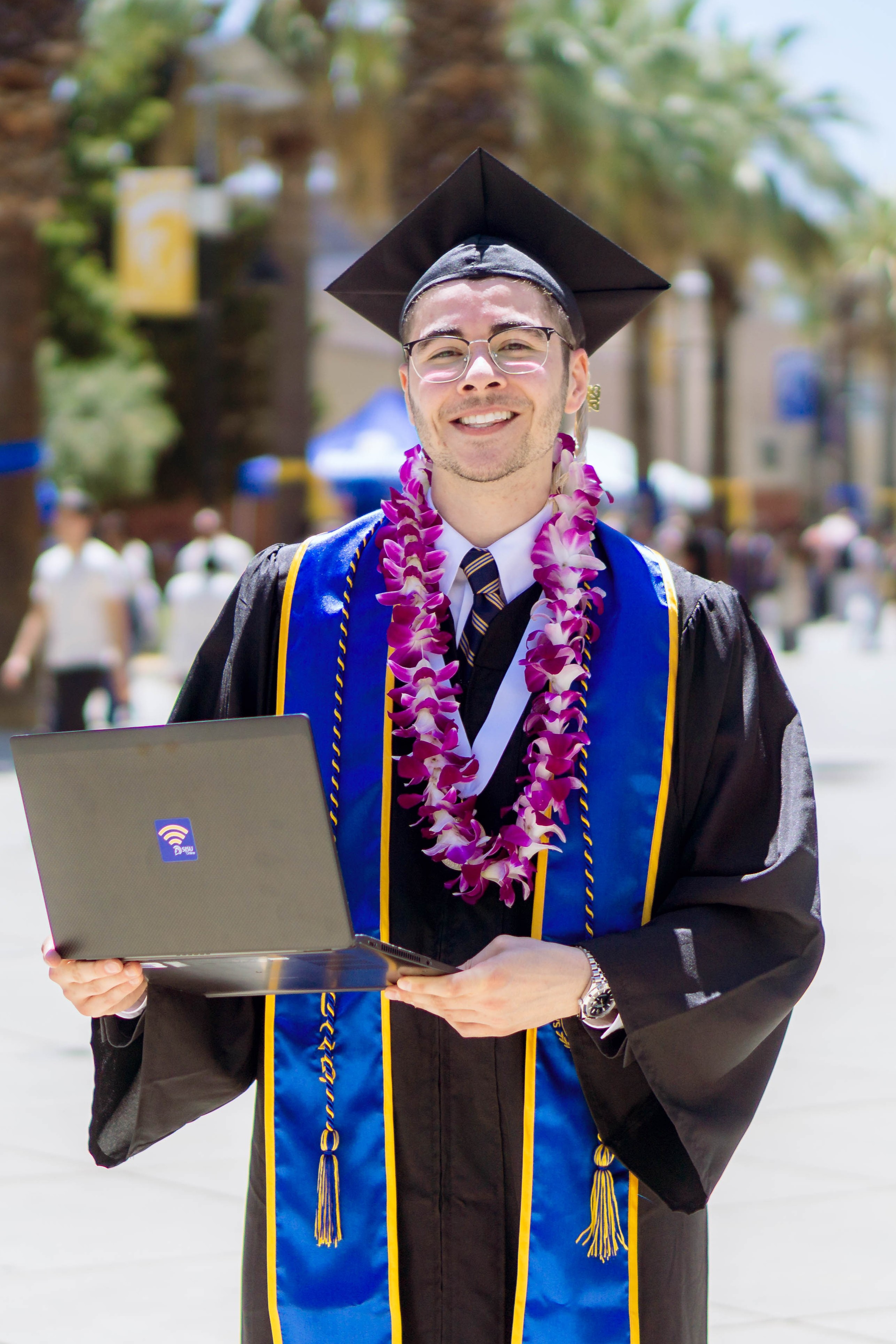 SJSU Online graduate smiling with laptop