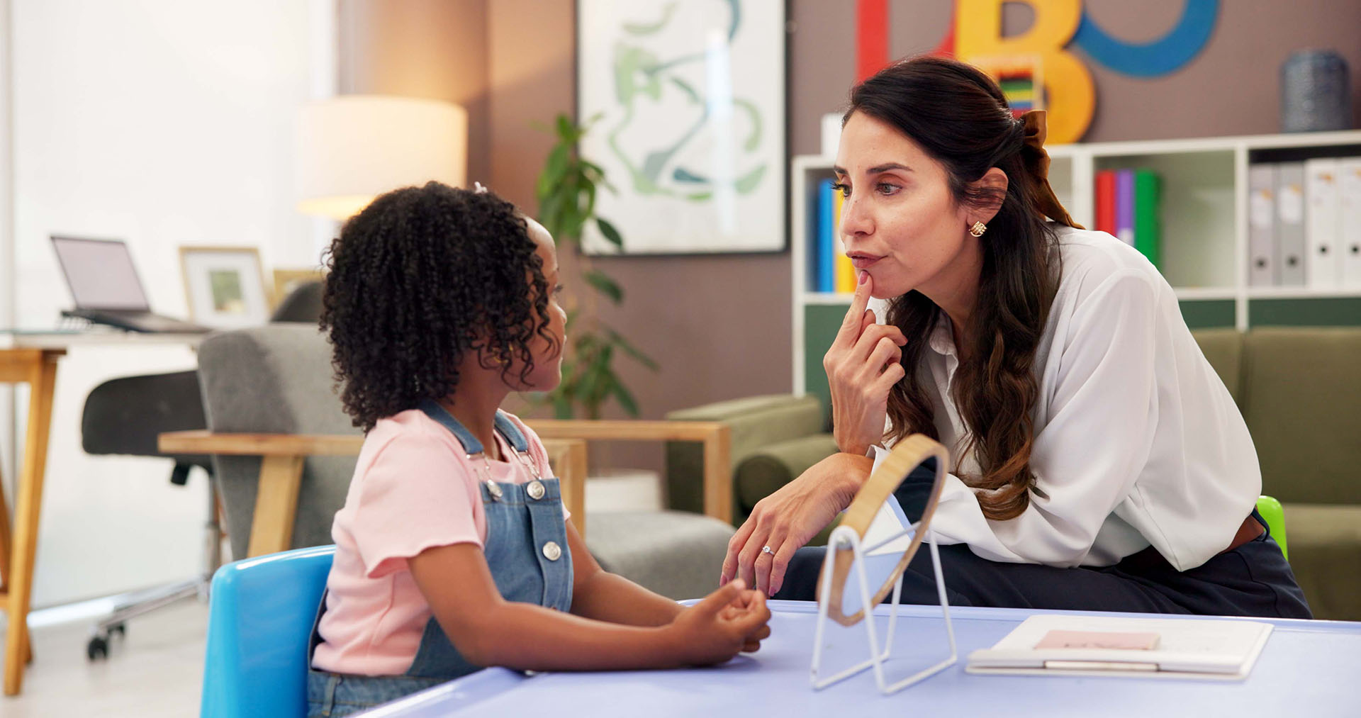 Adult providing speech therapy to child