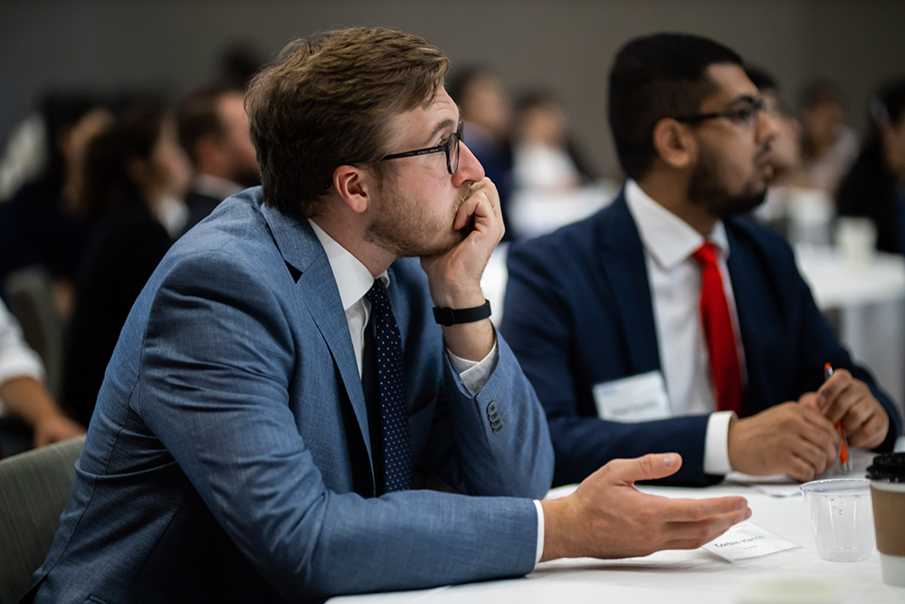 Students dressed in business casual listening attentively in class.