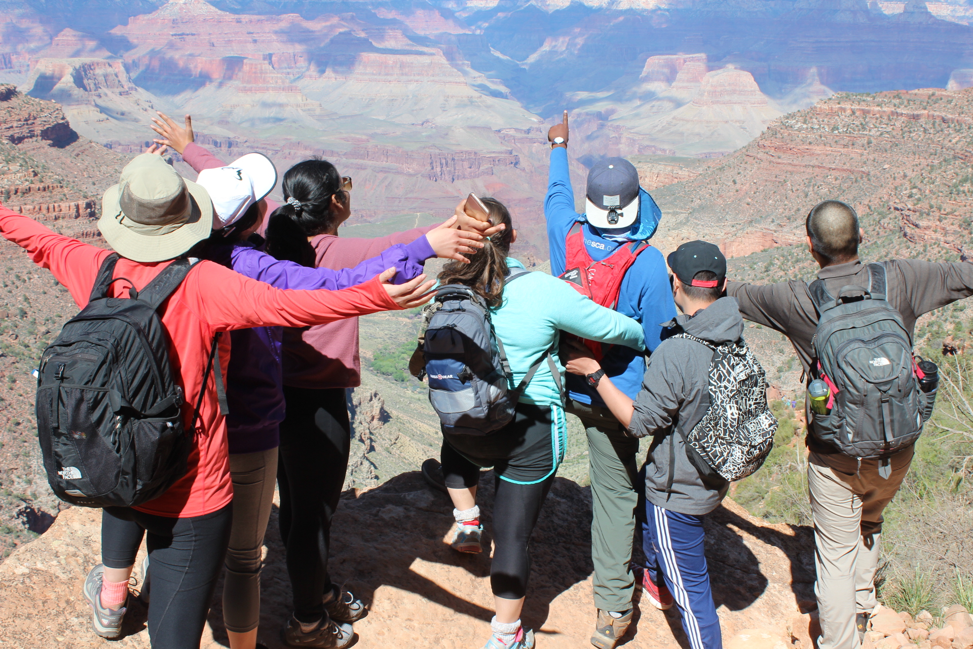 group of students standing over the grand canyon 