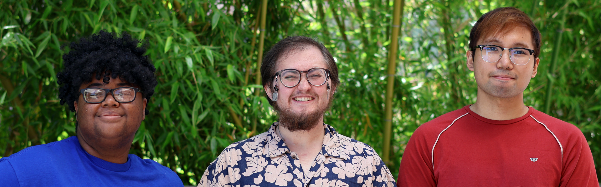 Team members facing camera smiling in front of bamboo scenic backdrop