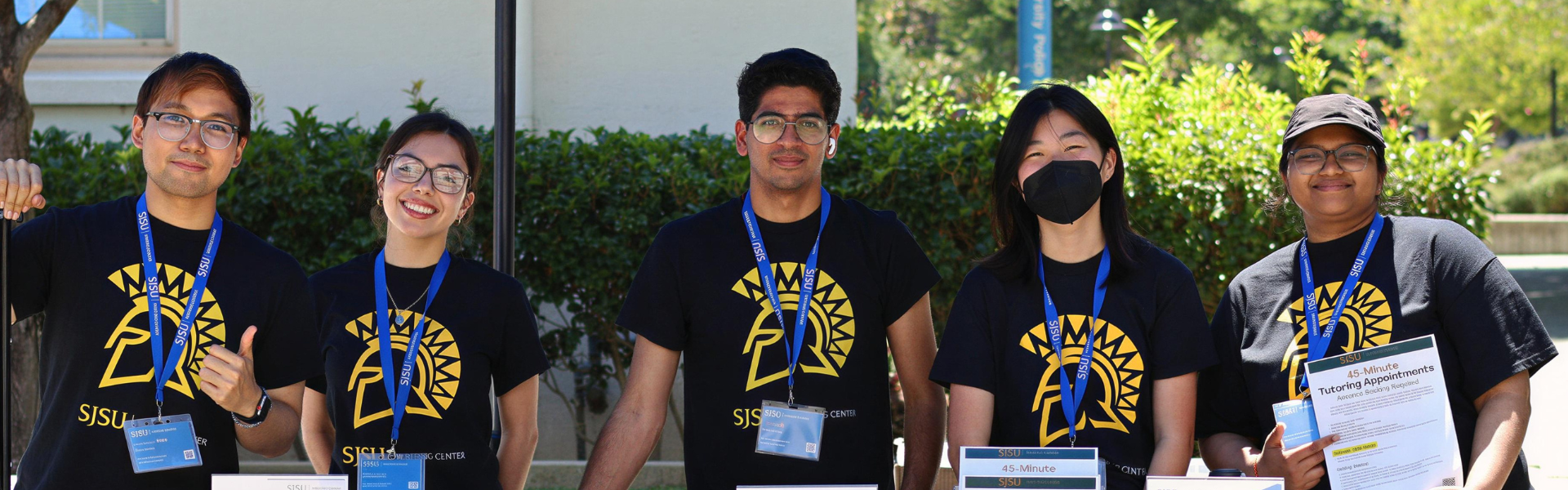 Writing Center team wearing black team tshirts and lanyards smiling at orientation event